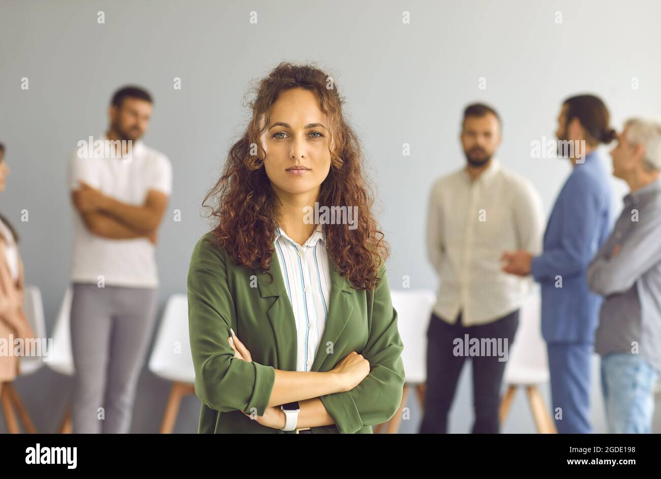 Portrait d'une jeune femme d'affaires debout dans une salle de bureau sur toile de fond des employés. Banque D'Images