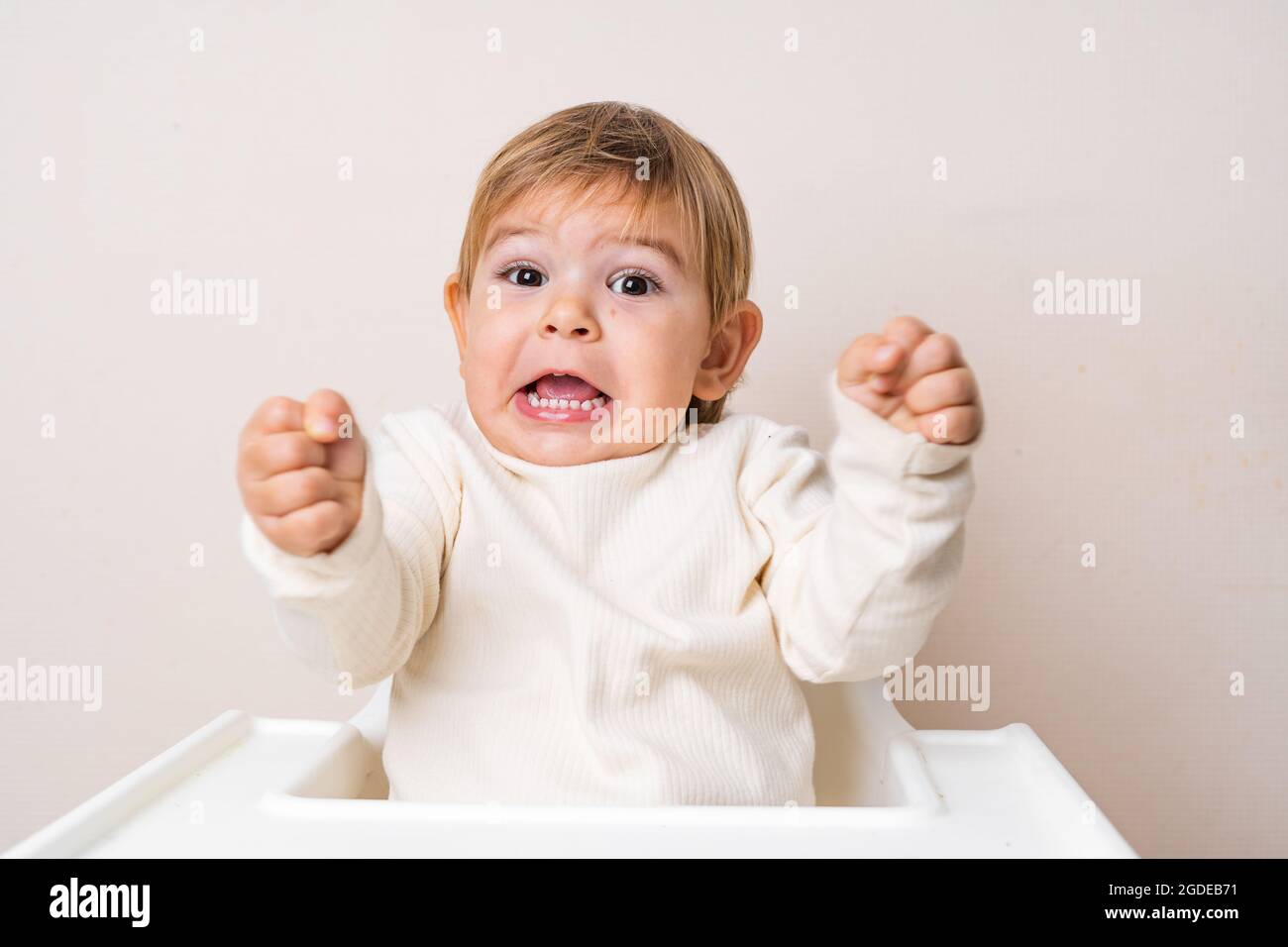 Bebe En Bas Age Assis Sur La Chaise Haute Et Faisant De La Grimace Drole Dents Du Bebe Expression De Face Photo Stock Alamy