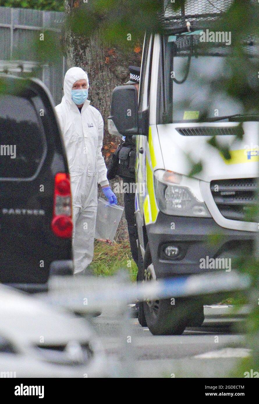 Un enquêteur de la police porte un sac de preuves dans l'avenue Royal Navy, dans la région de Keyham, à Plymouth, où six personnes, y compris le délinquant, sont mortes de blessures par balle dans un incident d'armes à feu jeudi soir. Date de la photo : vendredi 13 août 2021. Banque D'Images