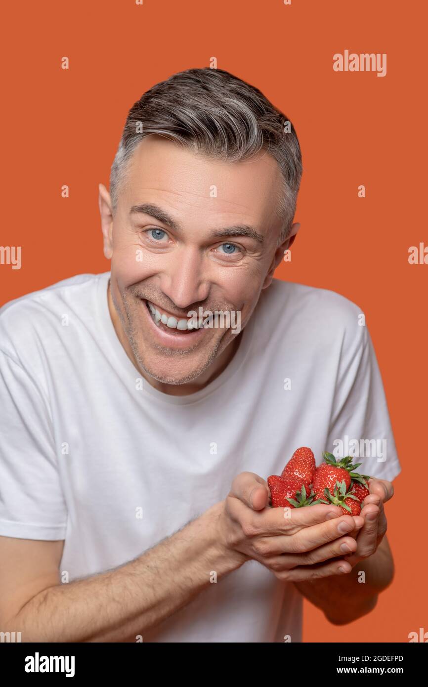 Réjouissez-vous avec des fraises mûres entre les mains Banque D'Images