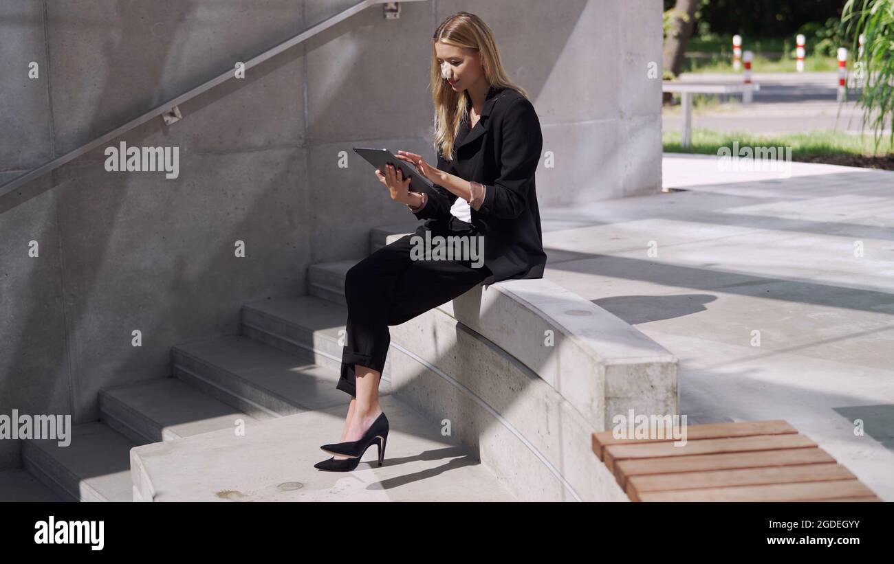 Femme de direction utilisant une tablette sur les marches Banque D'Images
