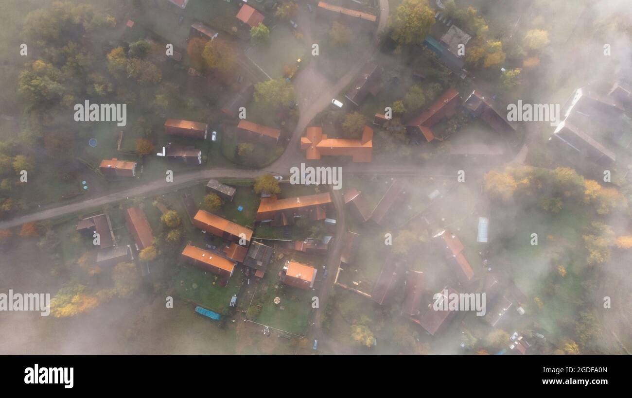 Vue aérienne du petit village dans le brouillard.vue du dessus du domaine traditionnel de l'habitation en tchèque.vue directement vers le bas avec le style d'image satellite.Maisons d'en haut Banque D'Images