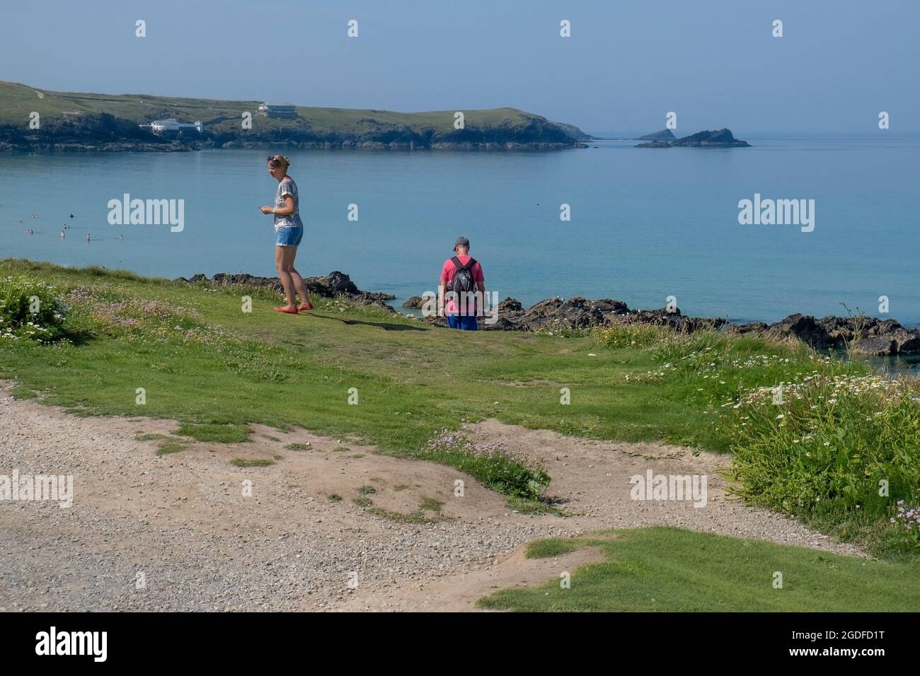 Vacanciers explorant la zone du sentier côtier au-dessus de la baie Fistral à Newquay, en Cornouailles. Banque D'Images