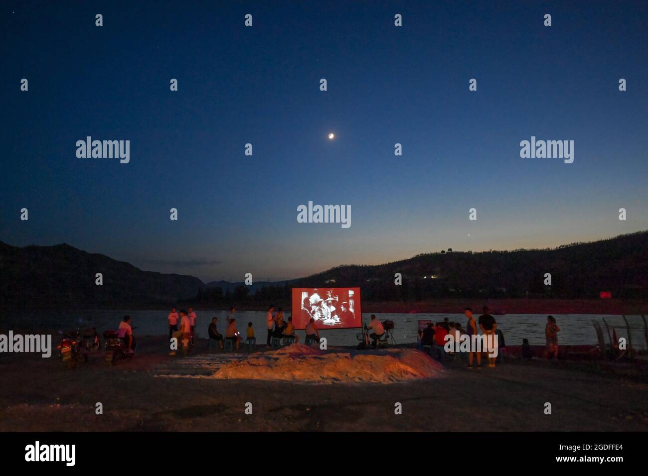 (210813) -- TAIYUAN, 13 août 2021 (Xinhua) -- les villageois voient un film en plein air de la rivière Yellow dans le canton de Sanjiao, comté de Liulin, province du Shanxi, dans le nord de la Chine, le 14 juillet 2021. En 1975, le canton de Sanjiao a créé une équipe de projection de films. Liu Bufei et Liu Dengzhao, tous deux cinéphiles depuis leur enfance, se sont joints à l'équipe et sont devenus des projectionnistes ruraux. En 2007, l'équipe est devenue une troïka alors que le projectionniste de deuxième génération Xue Xiaogang s'est joint à lui, qui avait vu des films en plein air dans le village tout en grandissant. Au fil des ans, l'équipe de projection, depuis un nombre incalculable de fois, a conduit le Banque D'Images