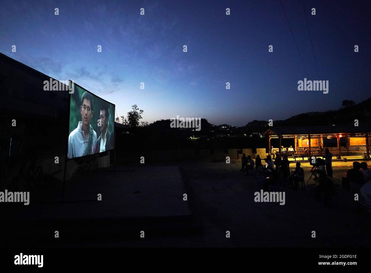 (210813) -- TAIYUAN, le 13 août 2021 (Xinhua) -- les villageois voient un film en plein air dans le village de Gaojiayan, canton de Sanjiao, comté de Liulin, province du Shanxi, au nord de la Chine, le 10 août 2021. En 1975, le canton de Sanjiao a créé une équipe de projection de films. Liu Bufei et Liu Dengzhao, tous deux cinéphiles depuis leur enfance, se sont joints à l'équipe et sont devenus des projectionnistes ruraux. En 2007, l'équipe est devenue une troïka alors que le projectionniste de deuxième génération Xue Xiaogang s'est joint à lui, qui avait vu des films en plein air dans le village tout en grandissant. Au fil des ans, l'équipe de projection, depuis d'innombrables temps, a conduit le long de la c Banque D'Images