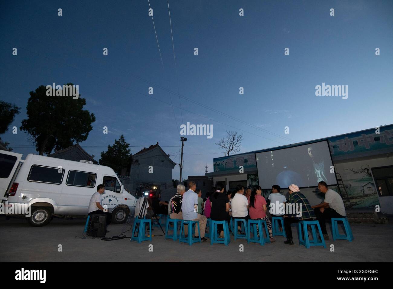 (210813) -- TAIYUAN, le 13 août 2021 (Xinhua) -- les villageois voient un film en plein air dans le village de Gaojiayan, canton de Sanjiao, comté de Liulin, province du Shanxi, au nord de la Chine, le 10 août 2021. En 1975, le canton de Sanjiao a créé une équipe de projection de films. Liu Bufei et Liu Dengzhao, tous deux cinéphiles depuis leur enfance, se sont joints à l'équipe et sont devenus des projectionnistes ruraux. En 2007, l'équipe est devenue une troïka alors que le projectionniste de deuxième génération Xue Xiaogang s'est joint à lui, qui avait vu des films en plein air dans le village tout en grandissant. Au fil des ans, l'équipe de projection, depuis d'innombrables temps, a conduit le long de la c Banque D'Images
