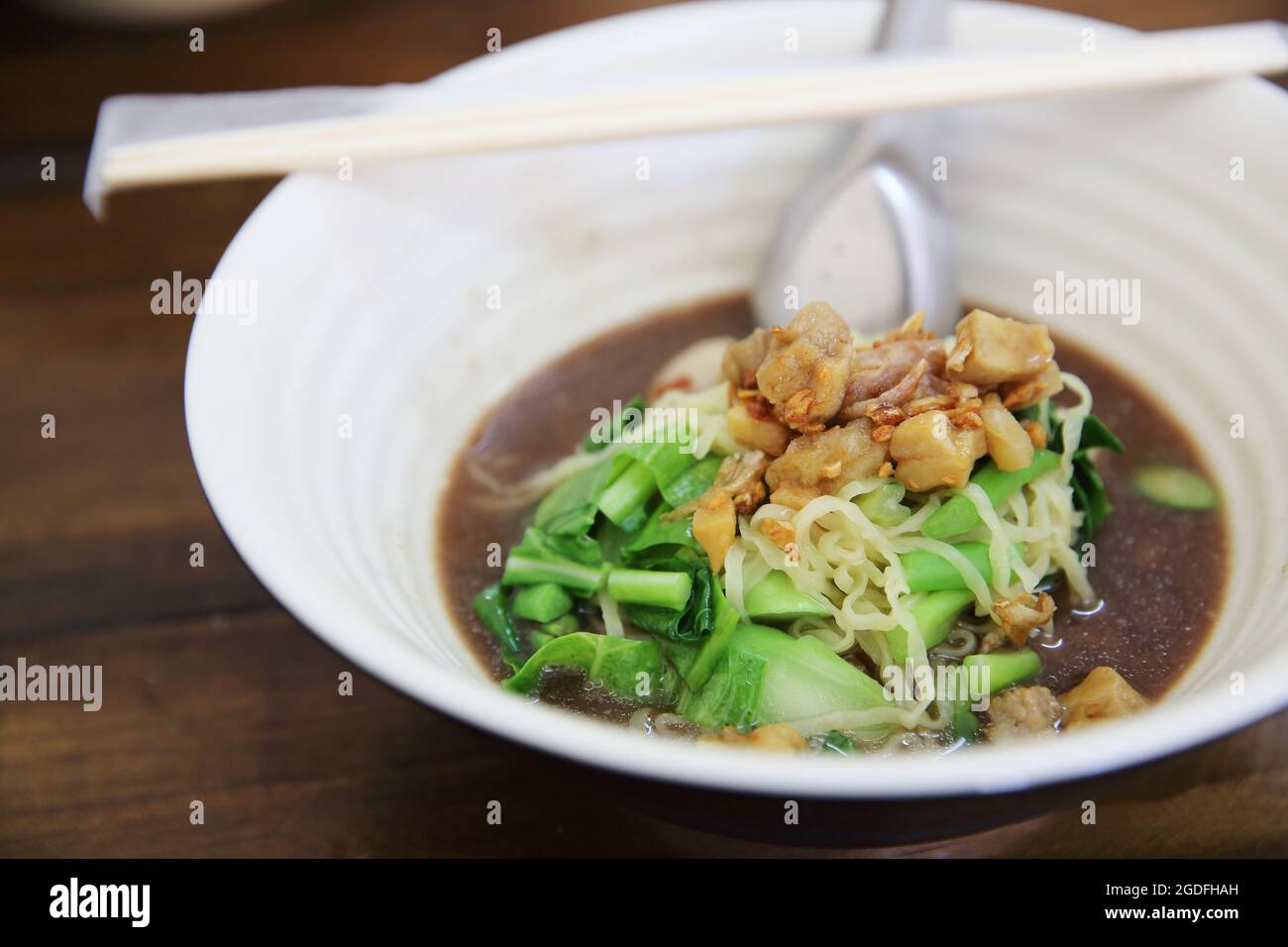 Nouilles avec soupe de bœuf sur fond de bois Banque D'Images