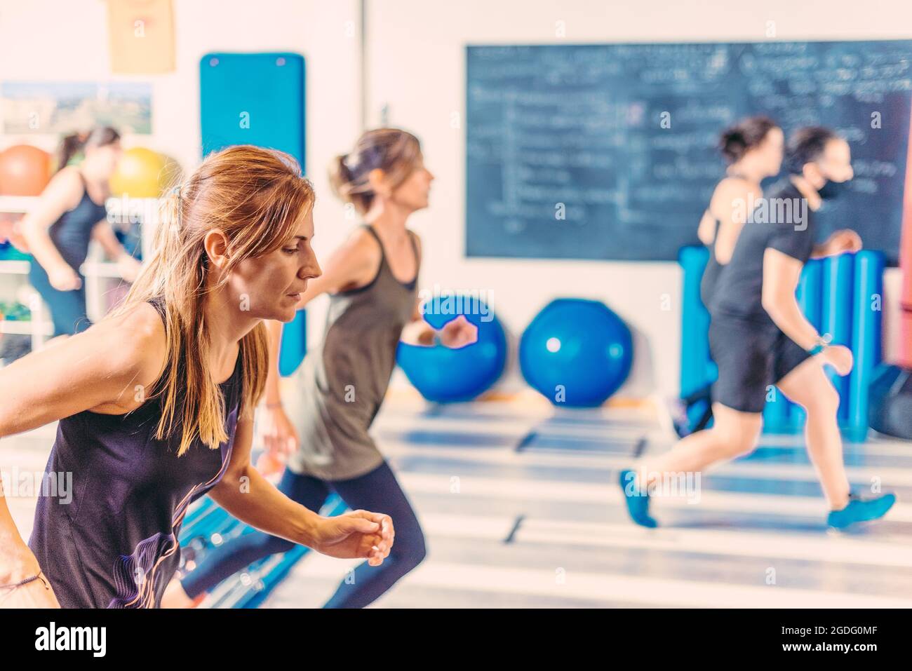 Vue latérale des femmes qui font des exercices aérobies dans le club de santé Banque D'Images