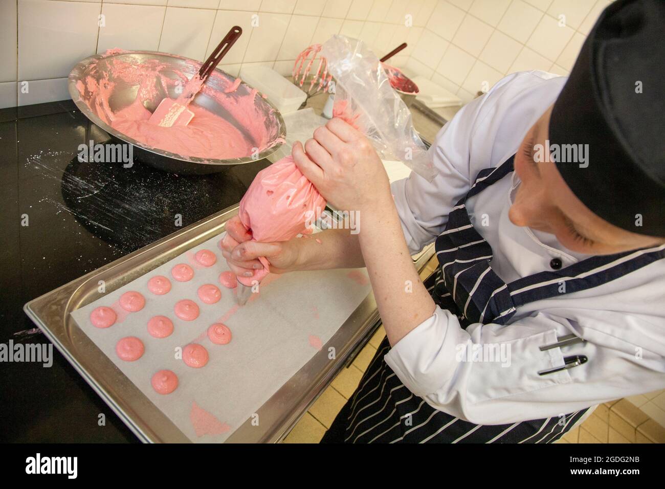Joanne Todd, chef pâtissière, fabrique des macarons roses Banque D'Images