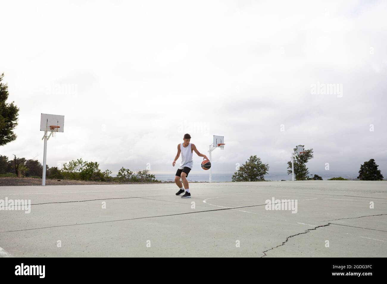 Joueur de basket-ball chez les hommes pratiquant avec balle sur un terrain de basket-ball Banque D'Images