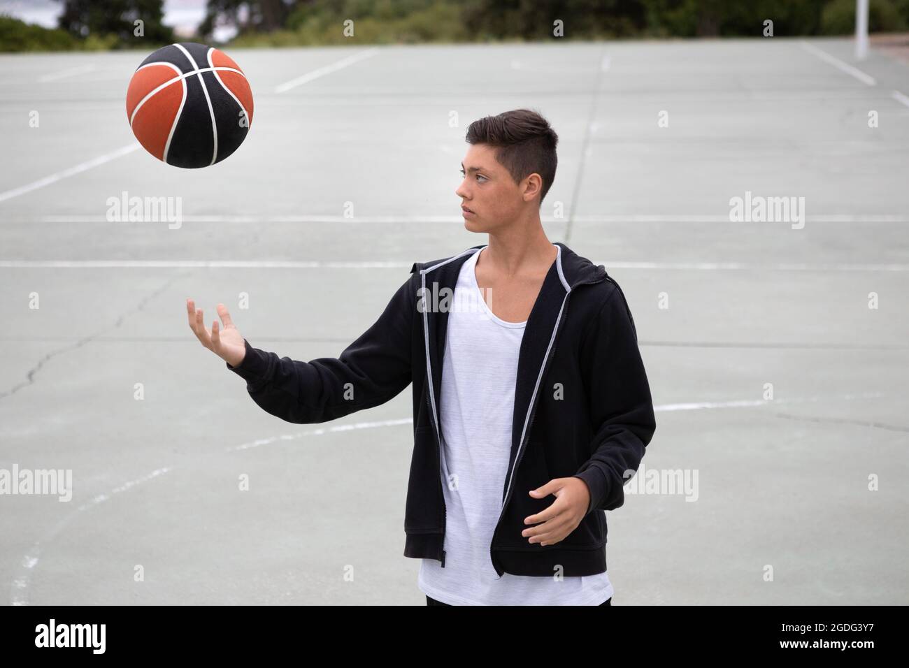 Les adolescents de sexe masculin de basket-ball sur un terrain de basket ball lancer et attraper Banque D'Images