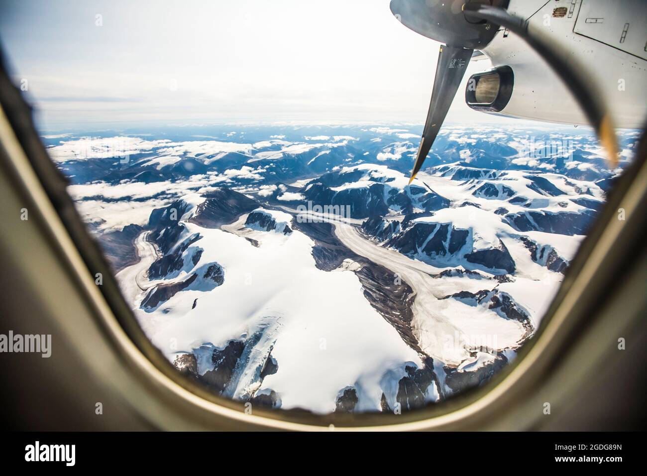 Vue aérienne des glaciers et des montagnes par une fenêtre d'avion. Banque D'Images