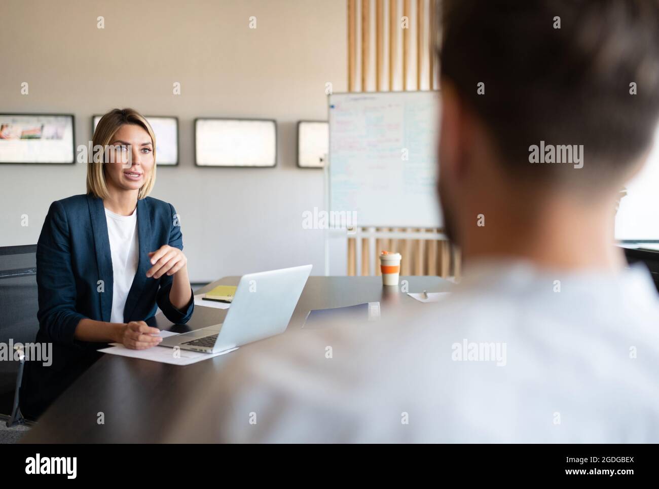 Femme entrepreneur avec ordinateur portable discutant des données avec un collègue de travail Banque D'Images Femme entrepreneur avec ordinateur portable discutant des données avec un collègue de travail Banque D'Images