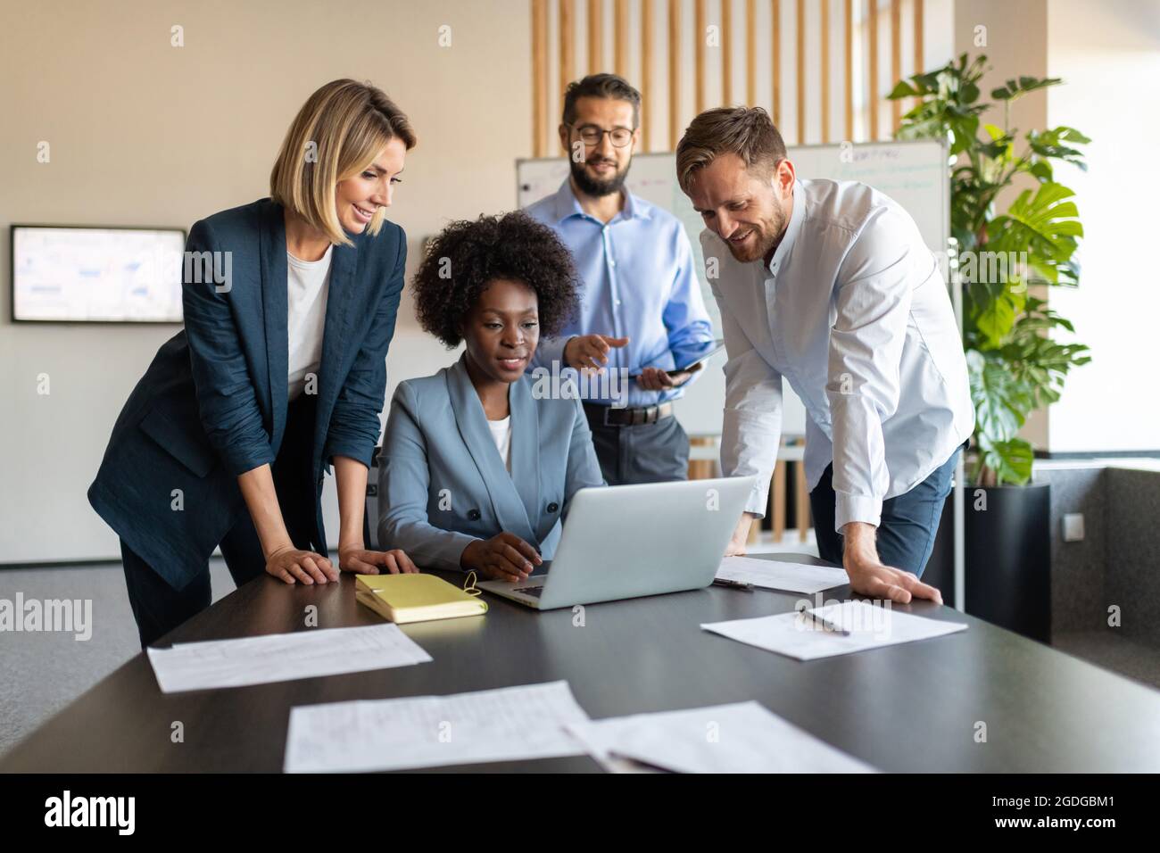 Divers hommes et femmes discutent de données sur netbook tout en travaillant ensemble sur un projet Banque D'Images Divers hommes et femmes discutent de données sur netbook tout en travaillant ensemble sur un projet Banque D'Images