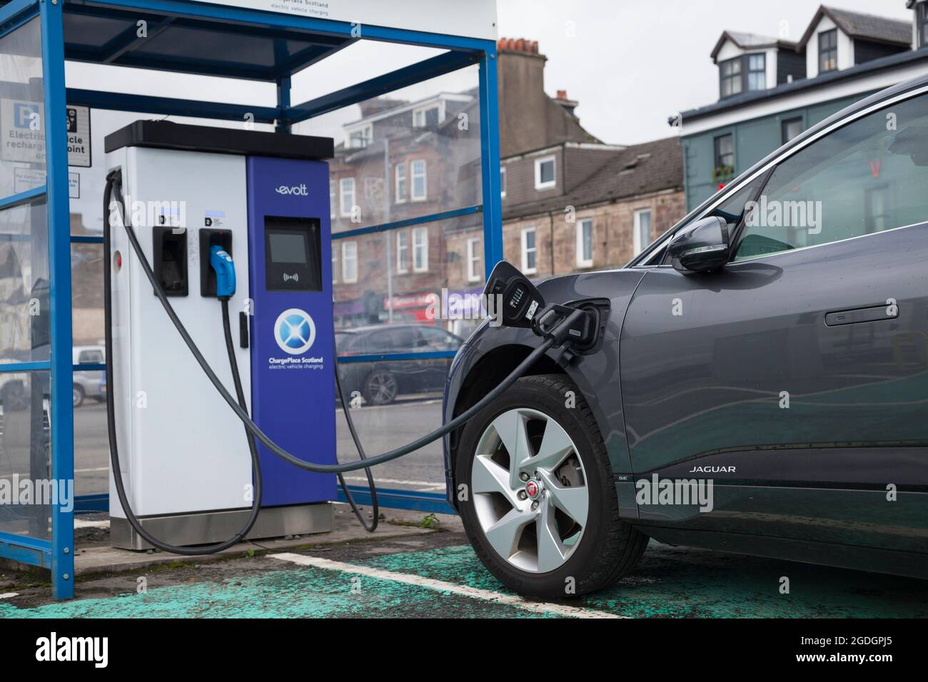 Voiture électrique au point de recharge public dans le parking. Banque D'Images