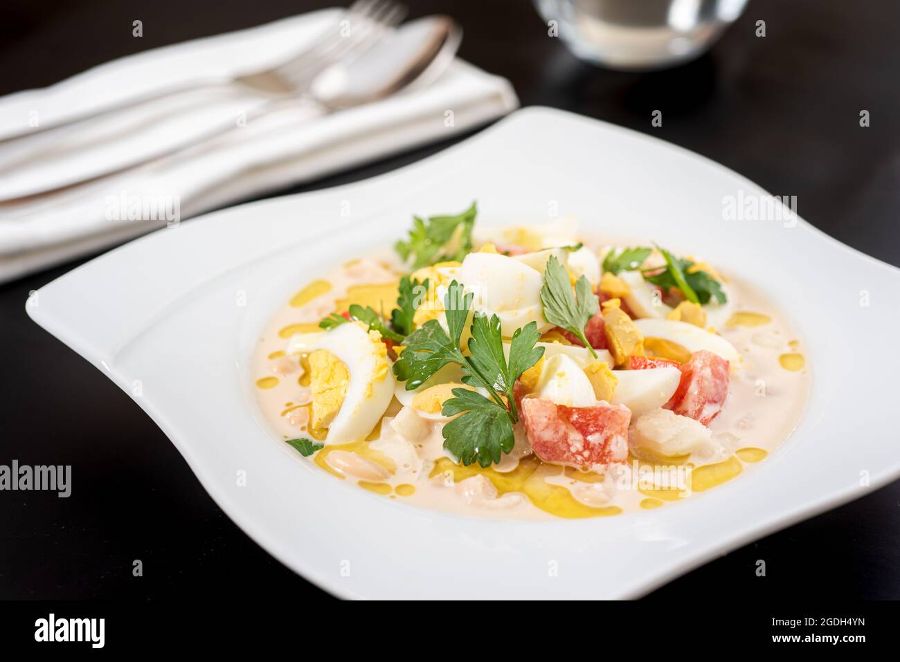 Salade de piyaz ou de haricots de style Antalya avec tahini et œuf sur une assiette en porcelaine blanche. Banque D'Images