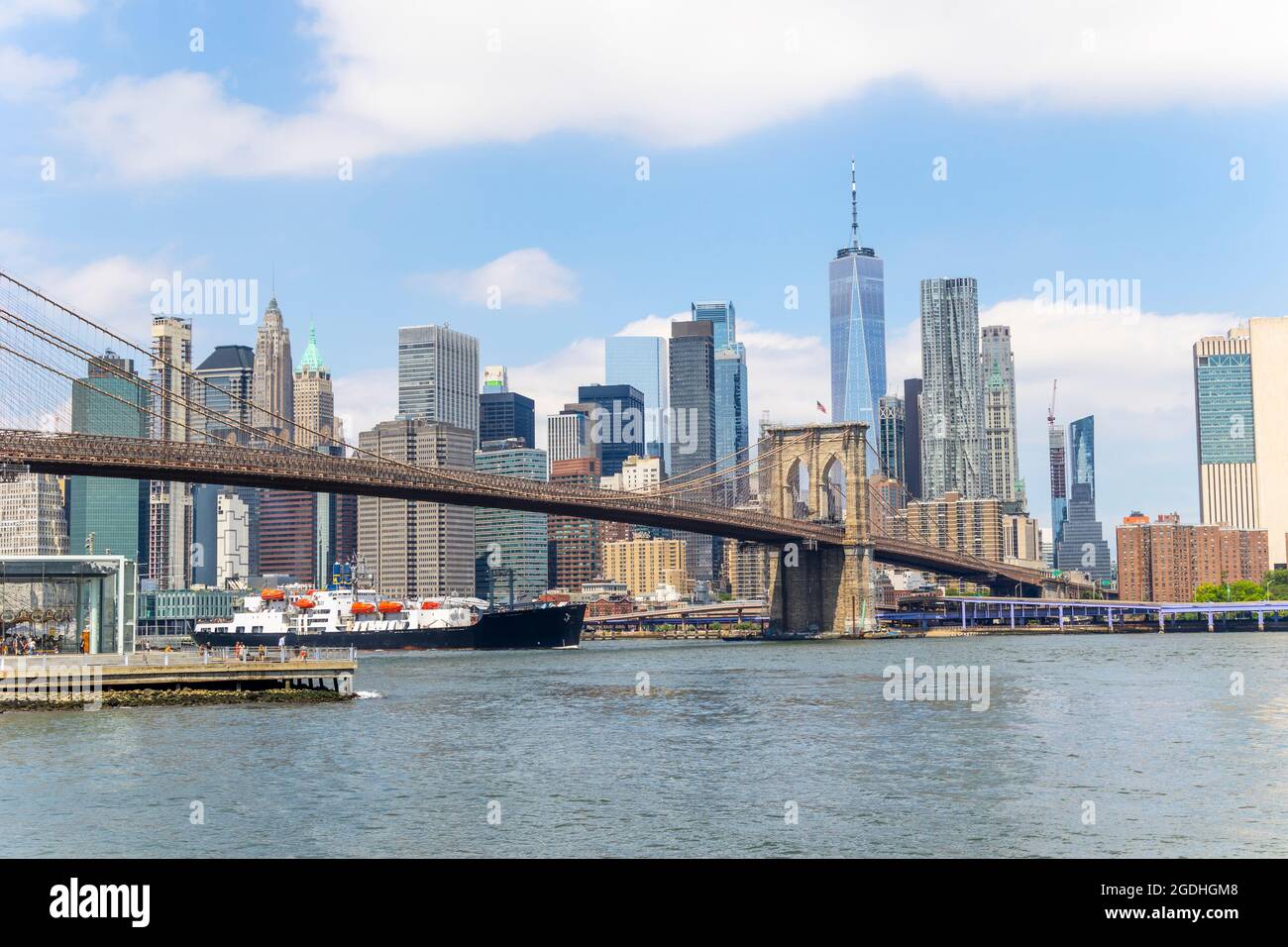 Un gros navire passe sous le pont de Brooklyn sur East River NYC Banque D'Images