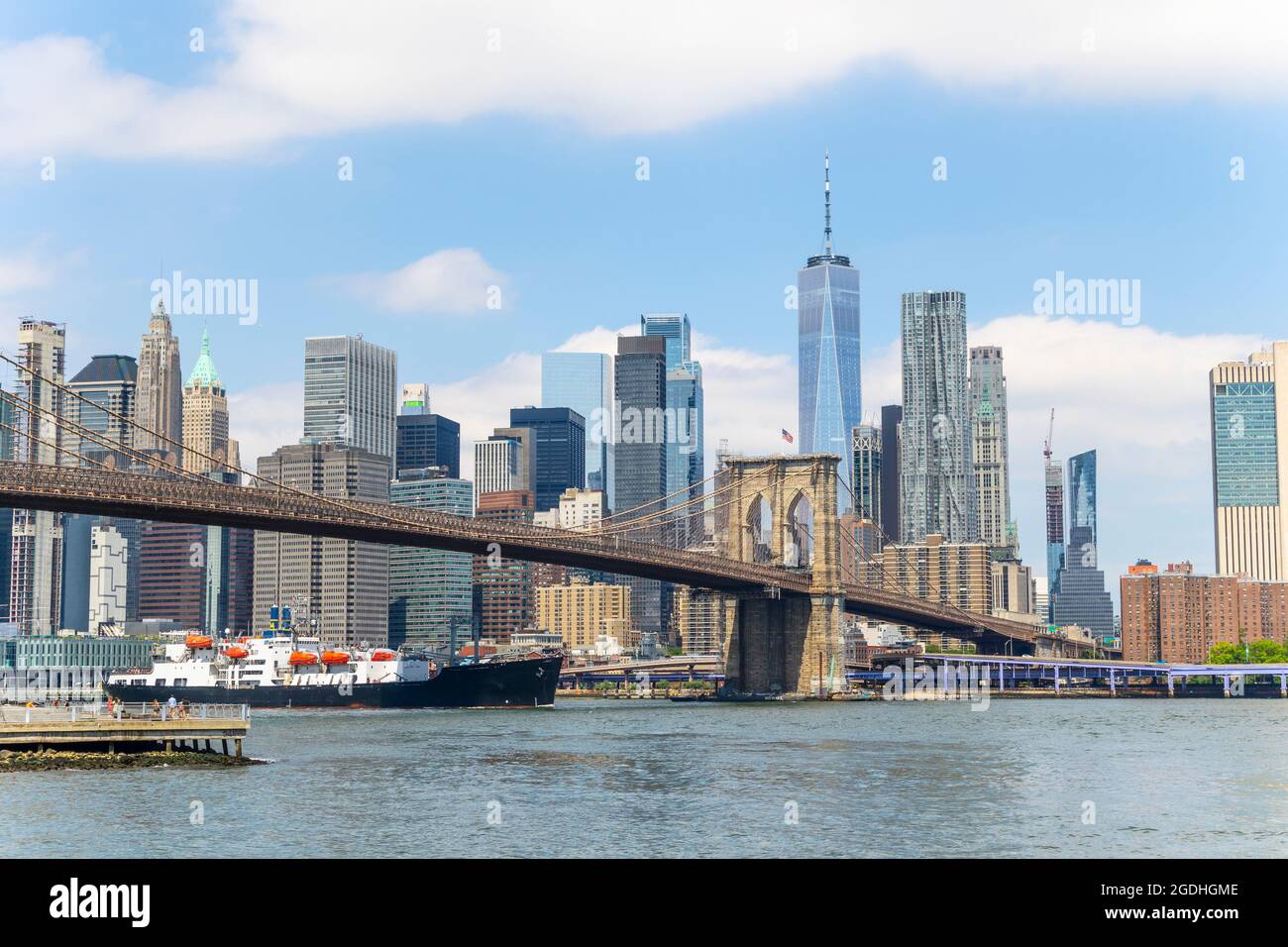 Un gros navire passe sous le pont de Brooklyn sur East River NYC Banque D'Images