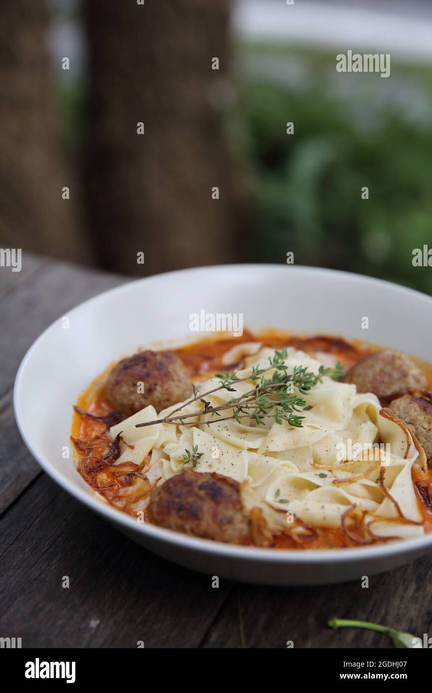 Boulettes de pâtes sauce tomate sur fond de bois Banque D'Images