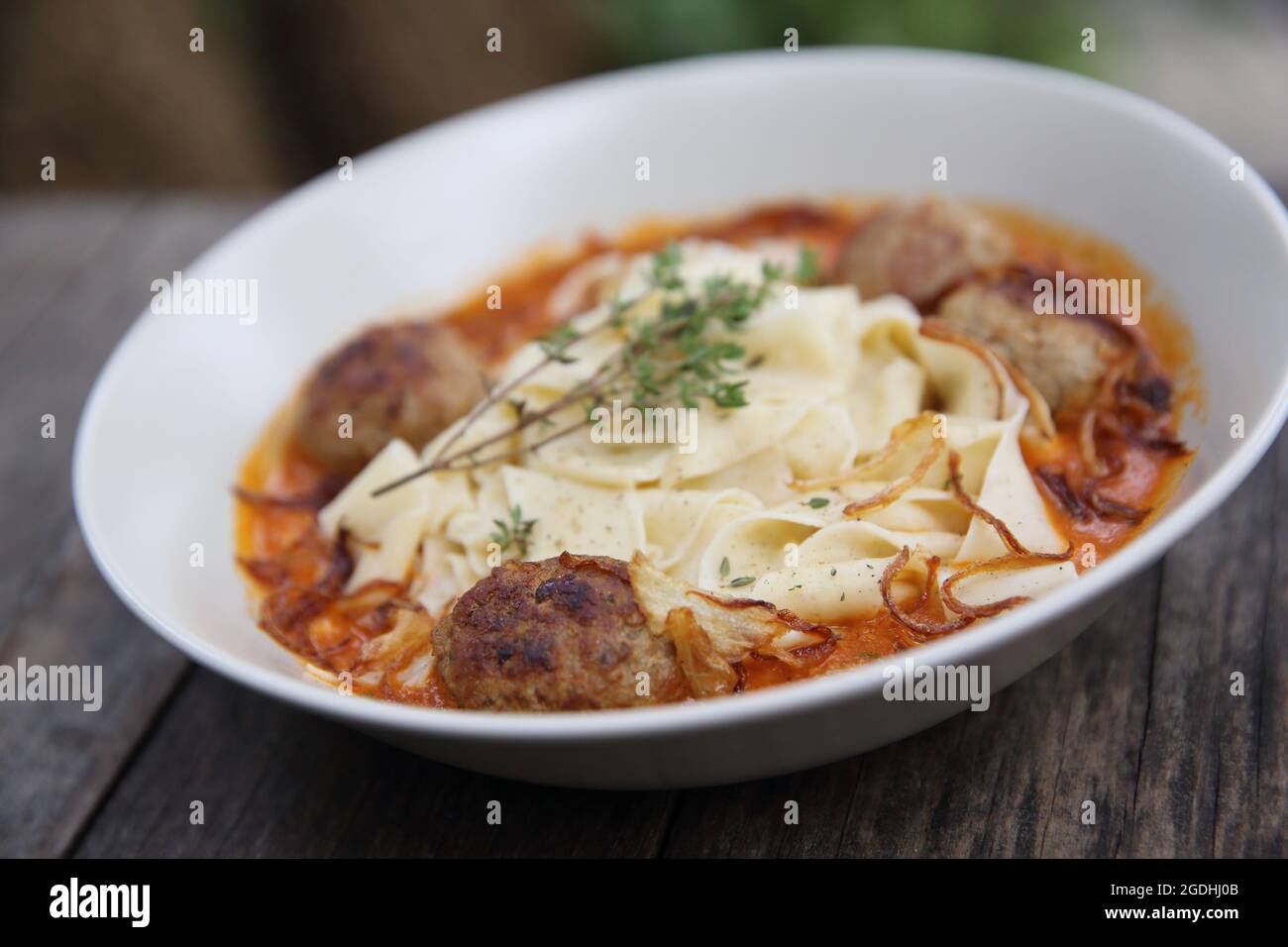 Boulettes de pâtes sauce tomate sur fond de bois Banque D'Images