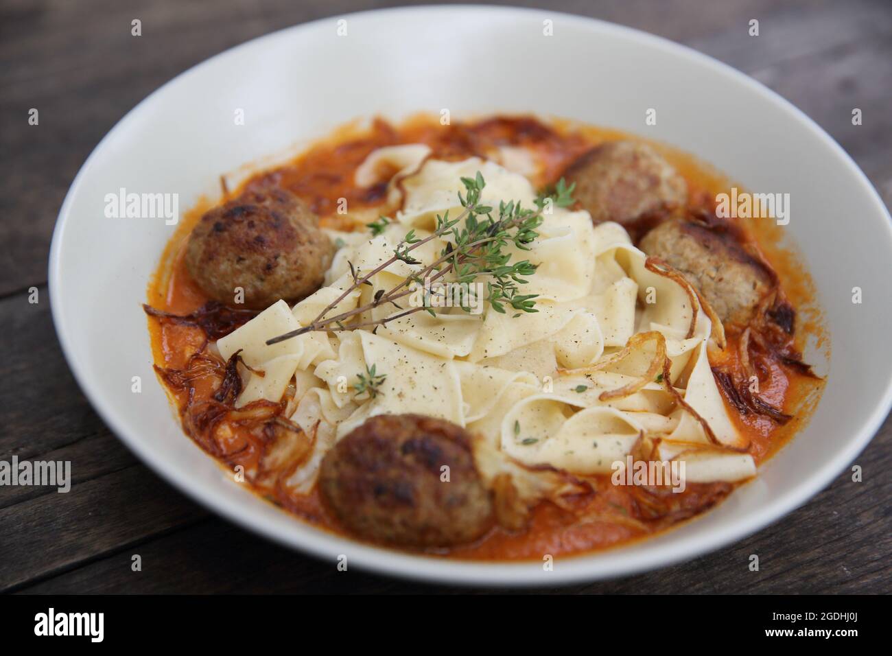Boulettes de pâtes sauce tomate sur fond de bois Banque D'Images