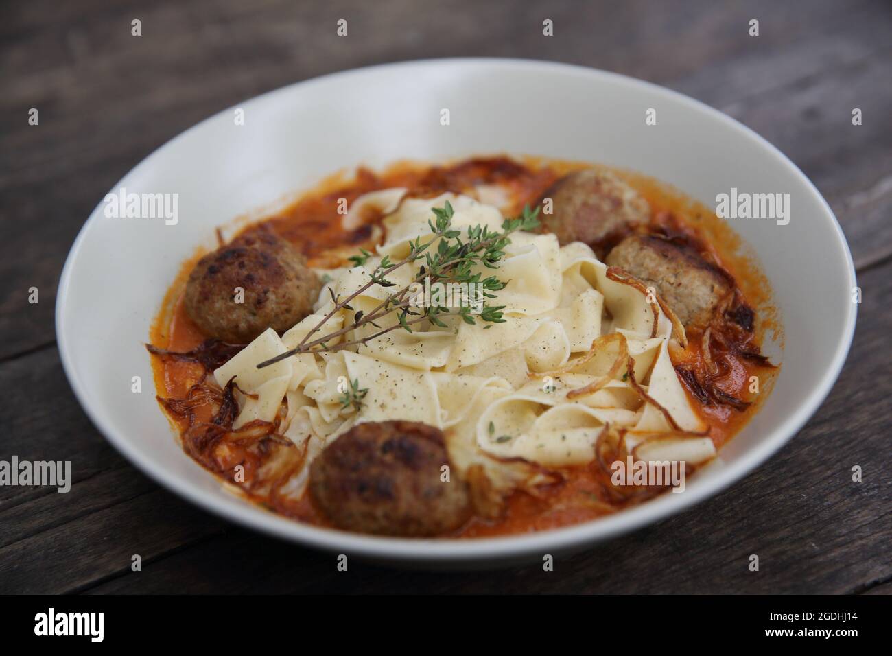 Boulettes de pâtes sauce tomate sur fond de bois Banque D'Images
