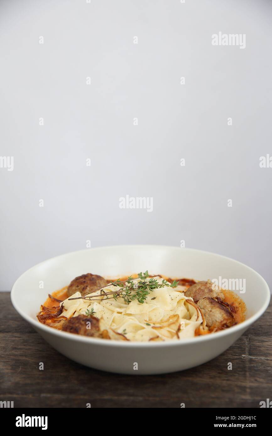 Boulettes de pâtes sauce tomate sur fond de bois Banque D'Images