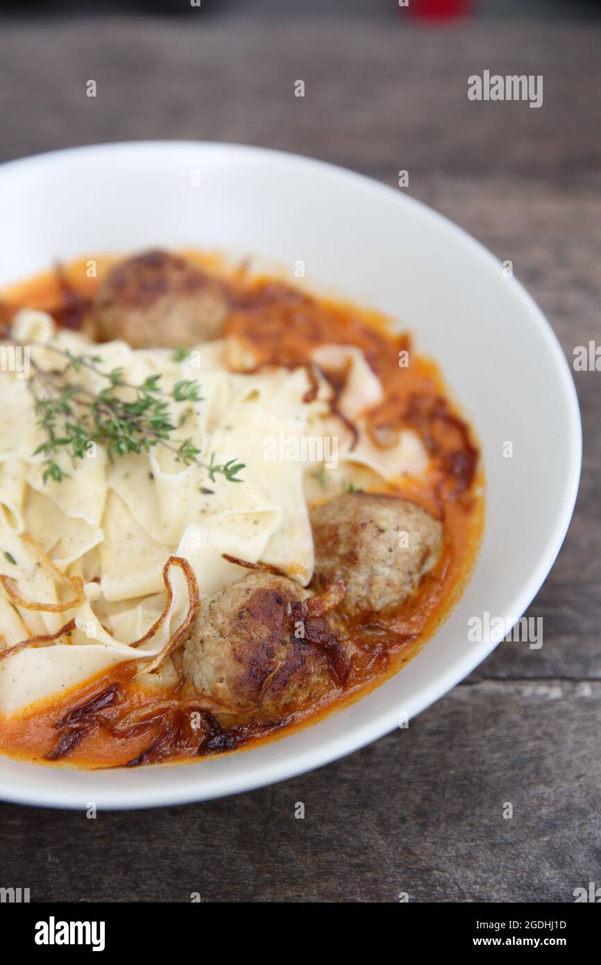 Boulettes de pâtes sauce tomate sur fond de bois Banque D'Images