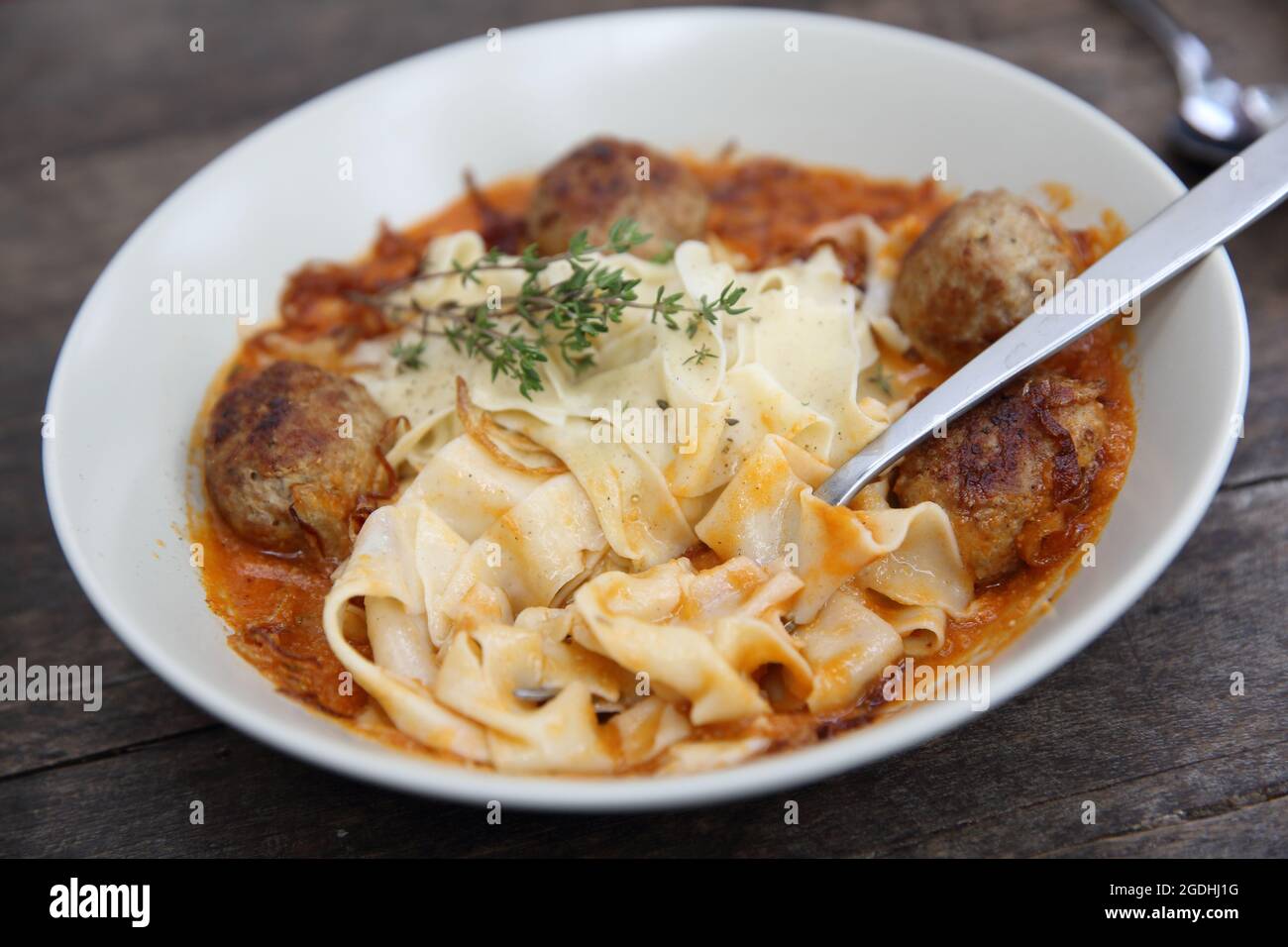 Boulettes de pâtes sauce tomate sur fond de bois Banque D'Images