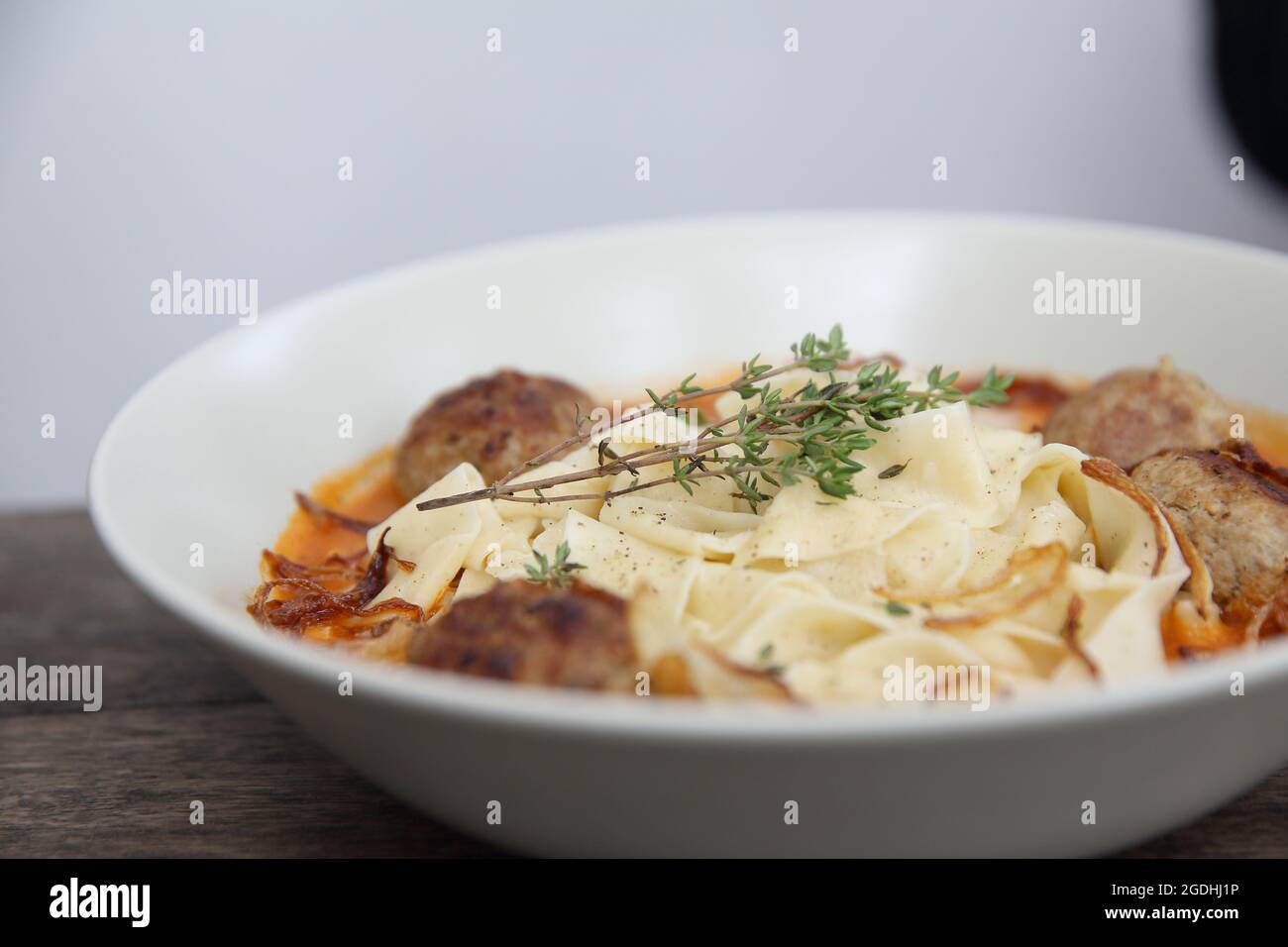 Boulettes de pâtes sauce tomate sur fond de bois Banque D'Images