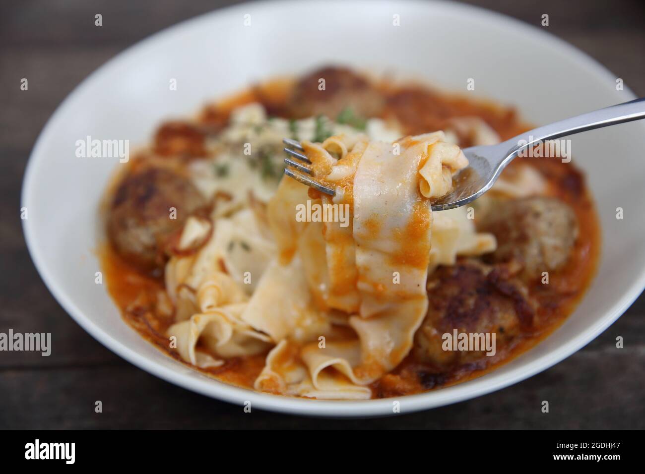 Boulettes de pâtes sauce tomate sur fond de bois Banque D'Images