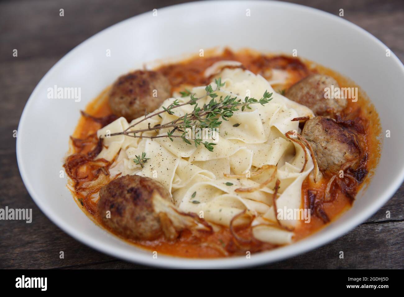 Boulettes de pâtes sauce tomate sur fond de bois Banque D'Images