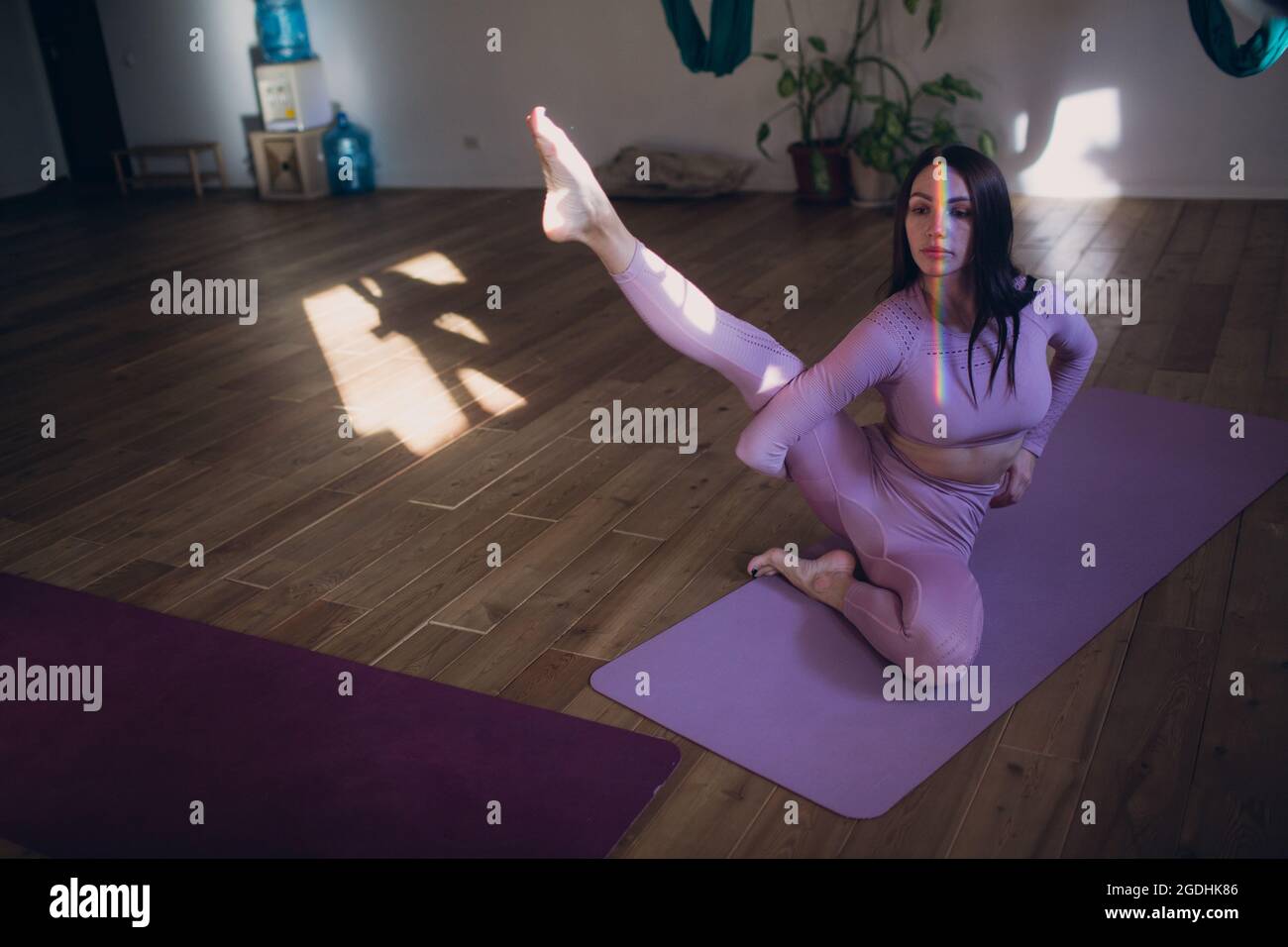 Femme faisant du yoga aérien en studio. Femme pratiquant le yoga aérien dans un hamac. Banque D'Images