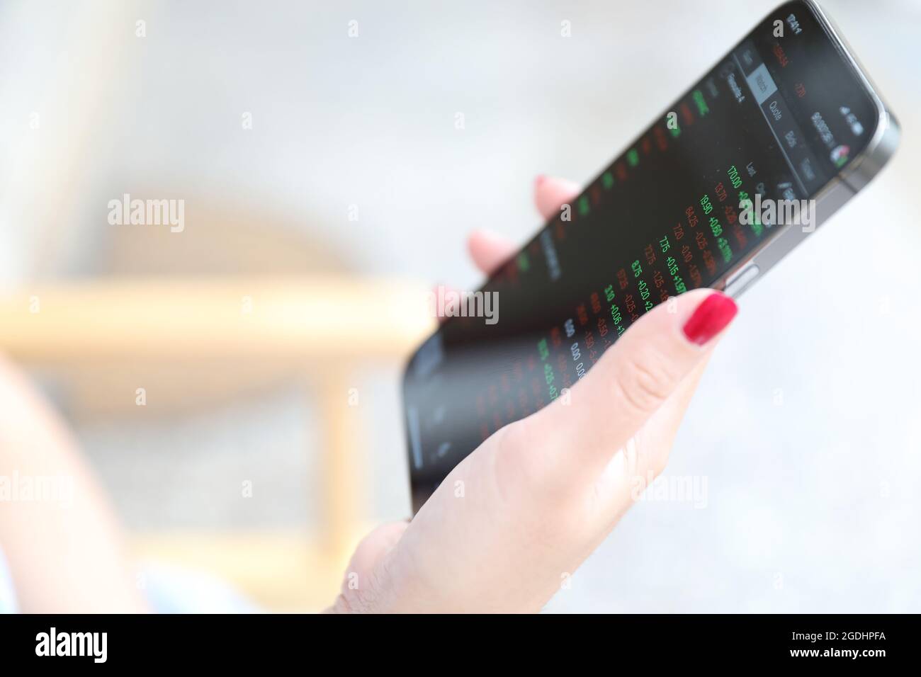 Main féminine avec smartphone trading stocks en ligne dans le café concept d'affaires Banque D'Images