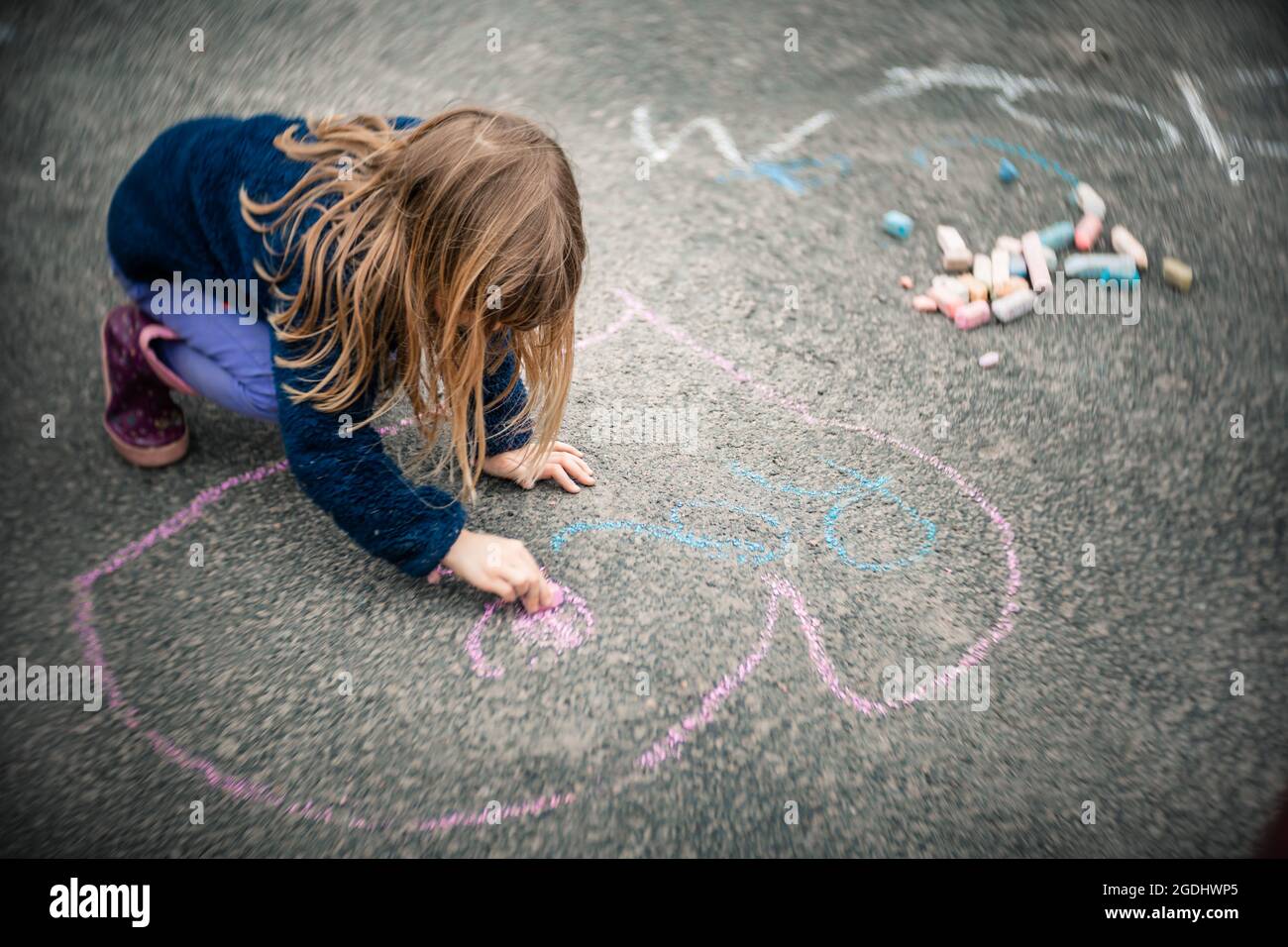 fille de 5 ans faisant quelques craies sur son allée Banque D'Images