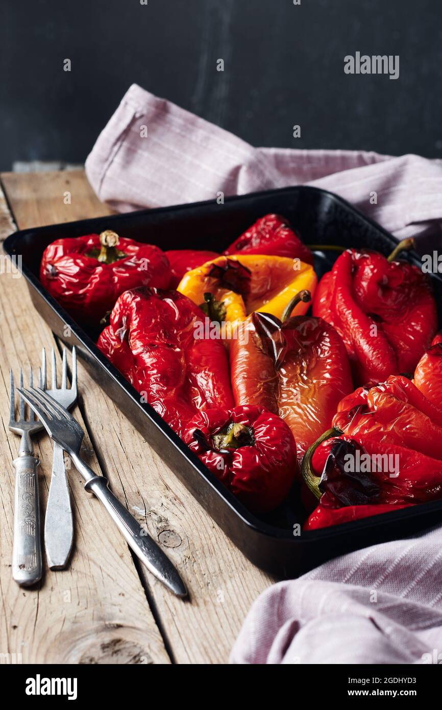 Poivrons rouges et jaunes grillés sur plaque de cuisson sur fond sombre. Banque D'Images