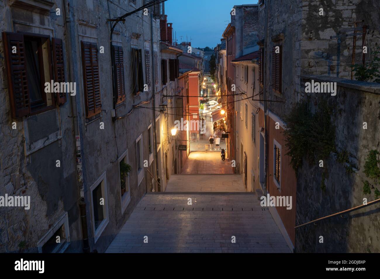 Vue en soirée sur la rue 'de Villeov uspon', au centre de la ville historique de Pula, Croatie. Les rues inférieures sous les escaliers sont éclairées et pleines de touristes. Banque D'Images