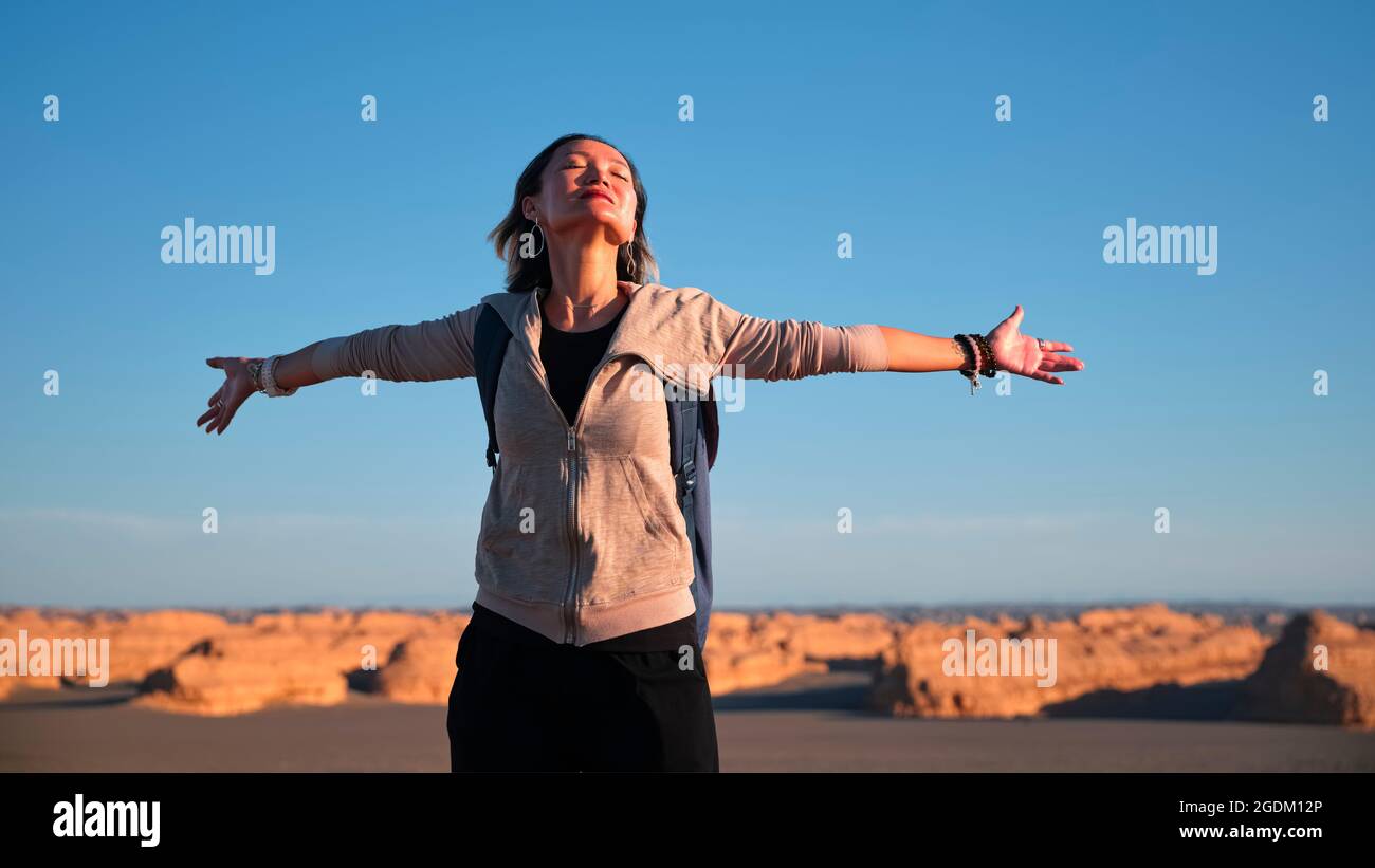 femme asiatique routard touriste appréciant la nature avec les bras dépasse les yeux fermés Banque D'Images