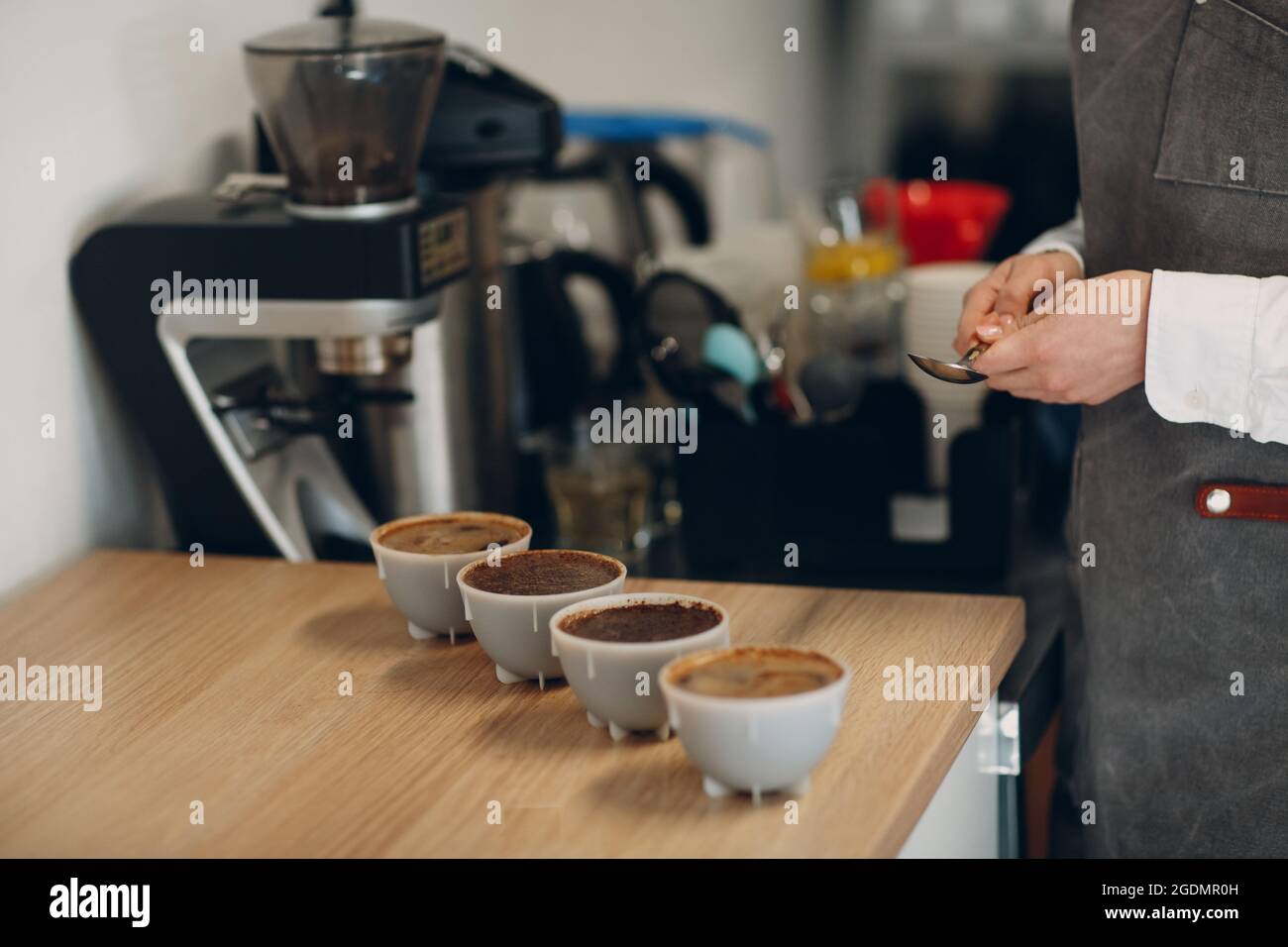 Tasse Tasster Femme avec cuillère en mains dégustation dégustation dégustation dégustation Test de qualité du café. Tasse à café. Banque D'Images