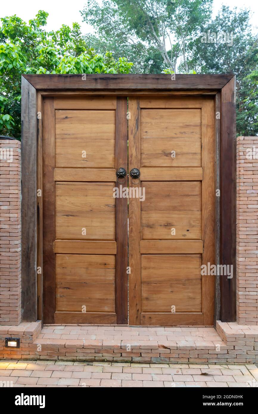 Porte en bois et cadre en bois avec le style de tête de lion chinois en  bronze. C'est au milieu du mur de briques dans le jardin Photo Stock - Alamy