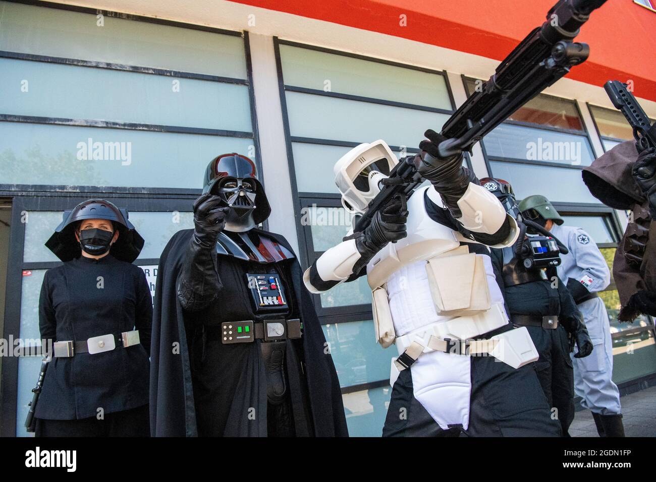 Duisburg, Allemagne. 14 août 2021. Les acteurs en costumes de la série de films Star Wars se tiennent devant le Centre de vaccination de Duisburg. Les enfants peuvent prendre leur photo avec les volontaires cinématiquement costumés après la vaccination. Crédit : Lino Mirgeler/dpa/Alay Live News Banque D'Images