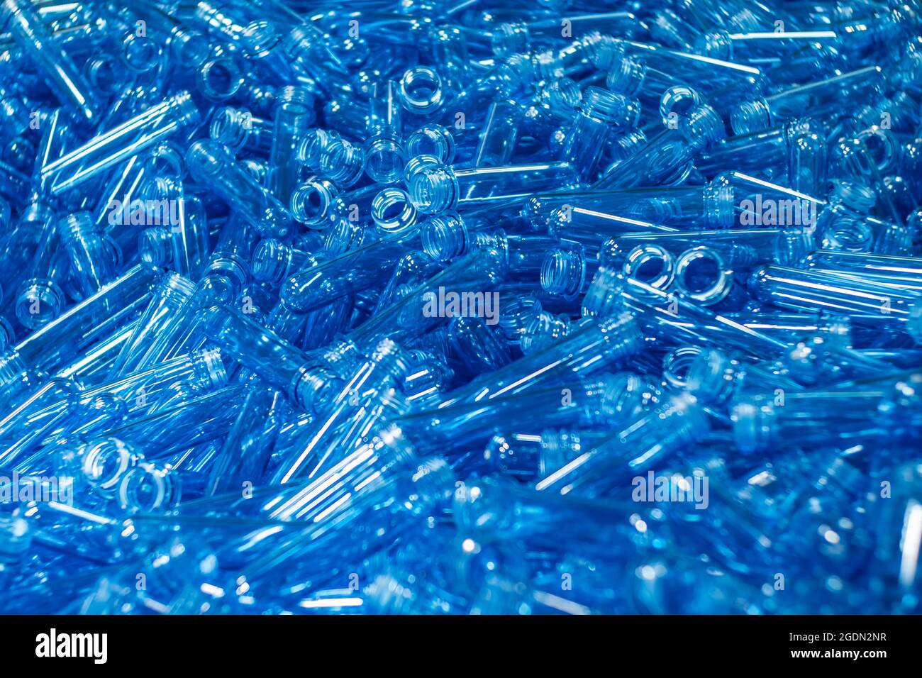 Pile de préformes en plastique bleu pour bouteilles d'un litre et demi. Mise au point sélective. Image d'arrière-plan. Production alimentaire Banque D'Images