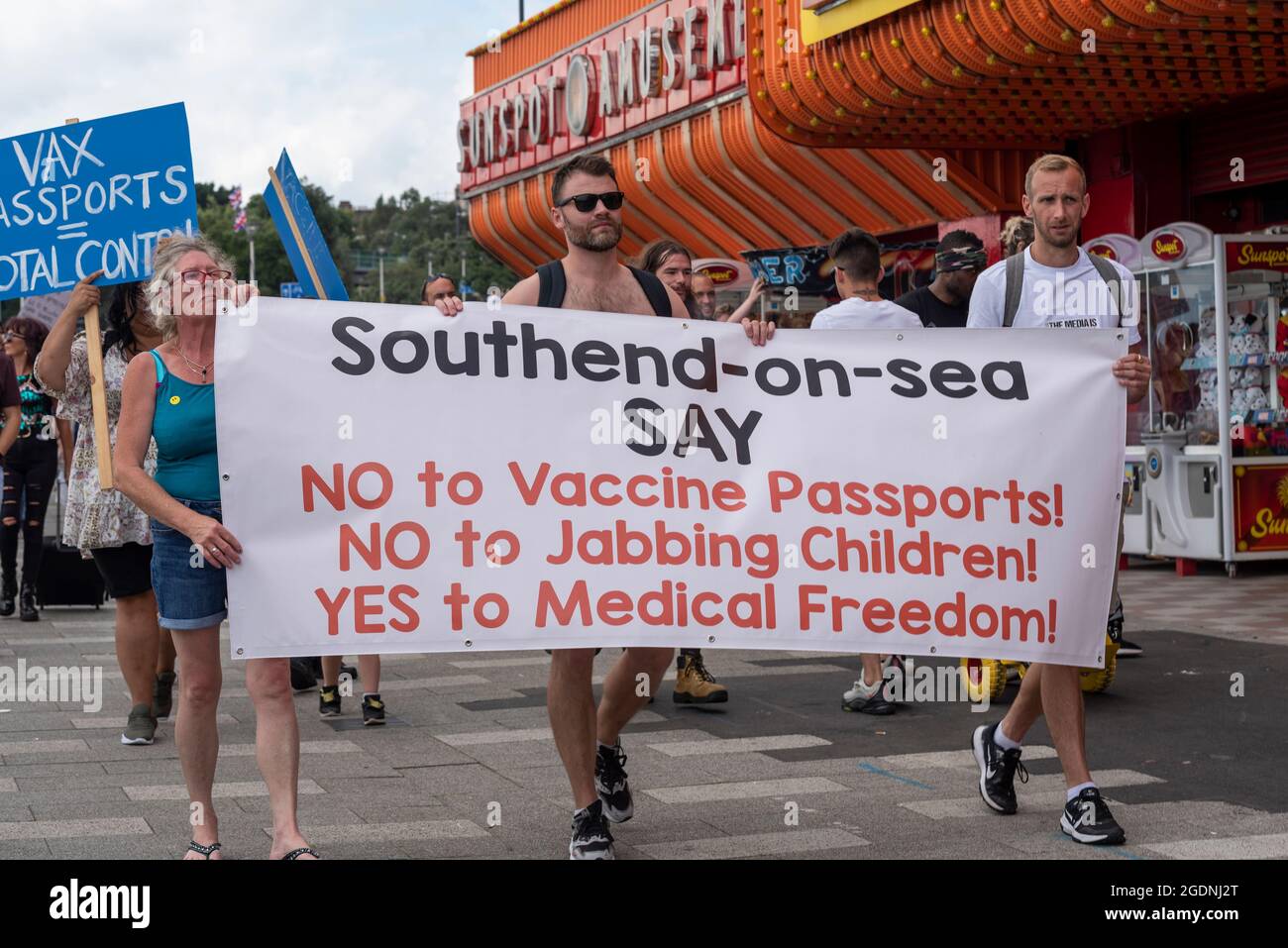 Southend on Sea, Essex, Royaume-Uni. 14 août 2021. Un certain nombre d'événements du rassemblement pour la liberté ont lieu dans le monde entier pour protester contre les passeports du vaccin COVID et les plans de vaccination des enfants. L'un d'eux est une marche de démonstration à Southend on Sea, avec des manifestants tenant des pancartes et des messages de chants alors qu'ils marchaient autour des attractions de la ville en bord de mer et bloquait les routes. Des manifestants avec une bannière passant devant une salle de jeux vidéo Banque D'Images