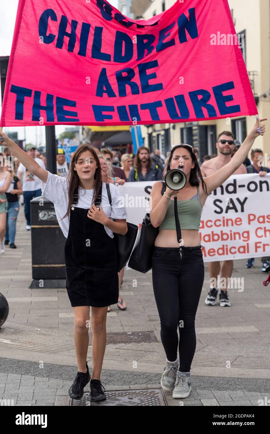 Southend on Sea, Essex, Royaume-Uni. 14 août 2021. Un certain nombre d'événements du rassemblement pour la liberté ont lieu dans le monde entier pour protester contre les passeports du vaccin COVID et les plans de vaccination des enfants. L'une de ces manifestations est une marche de démonstration à Southend on Sea, avec des manifestants tenant des pancartes et des messages de chants alors qu'ils marchaient autour des attractions de la ville en bord de mer et bloquait les routes. Jeunes femmes menant une marche le long du front de mer avec un message de bannière, les enfants sont l'avenir Banque D'Images