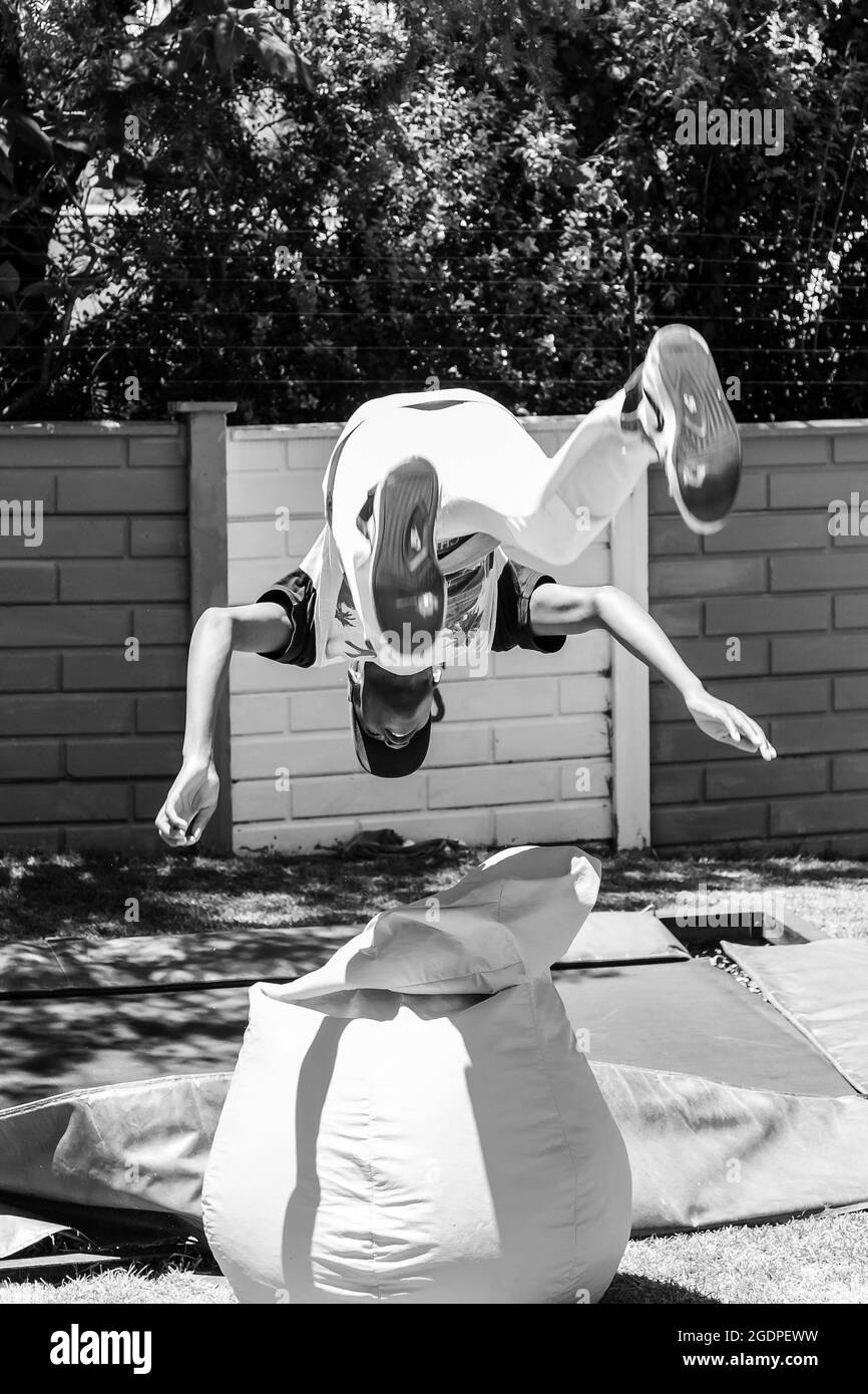JOHANNESBURG, AFRIQUE DU SUD - 05 janvier 2021 : une photo verticale d'un jeune homme africain qui saute et fait des tours sur un trampoline Banque D'Images