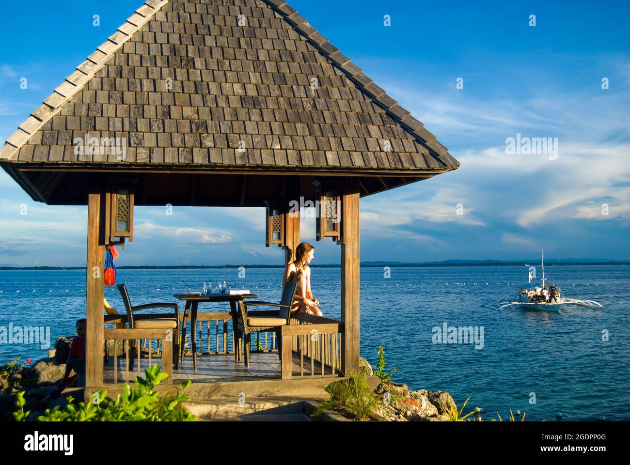 Un abri au bord de l'eau au coucher du soleil, le Shangri-La Island Resort & Spa, Mactan Island, Cebu, Visayas, Philippines Banque D'Images Un abri au bord de l'eau au coucher du soleil, le Shangri-La Island Resort & Spa, Mactan Island, Cebu, Visayas, Philippines Banque D'Images
