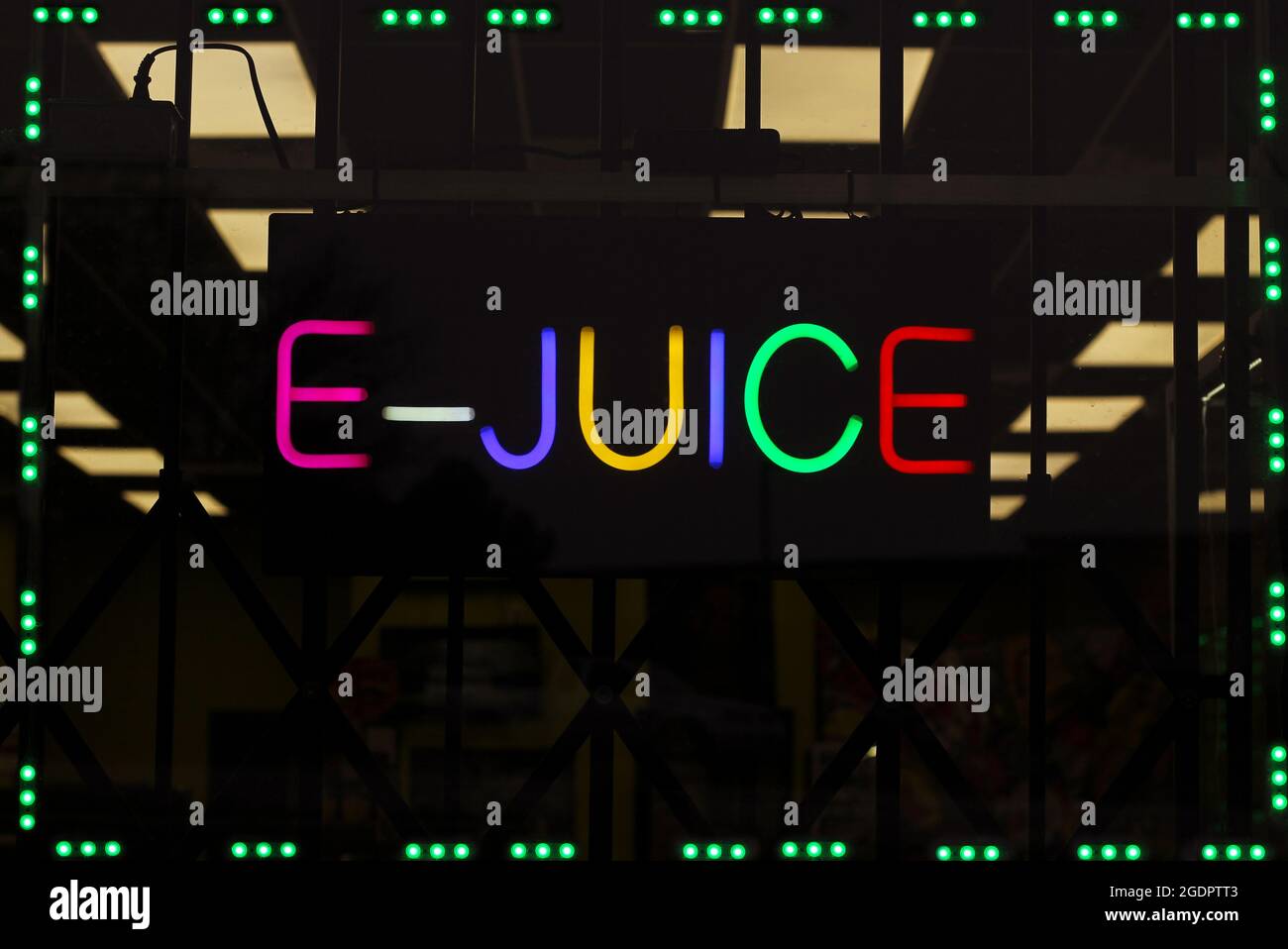 Affiche pour le jus de fruits électroniques au néon dans la fenêtre du magasin de fumée Banque D'Images