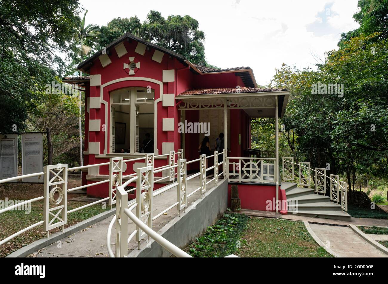 Vue sur la petite maison de palais rouge du centre de référence historique de la cartographie, entourée par les jardins verdoyants de l'UFMG. Quartier de Santa Ines. Banque D'Images