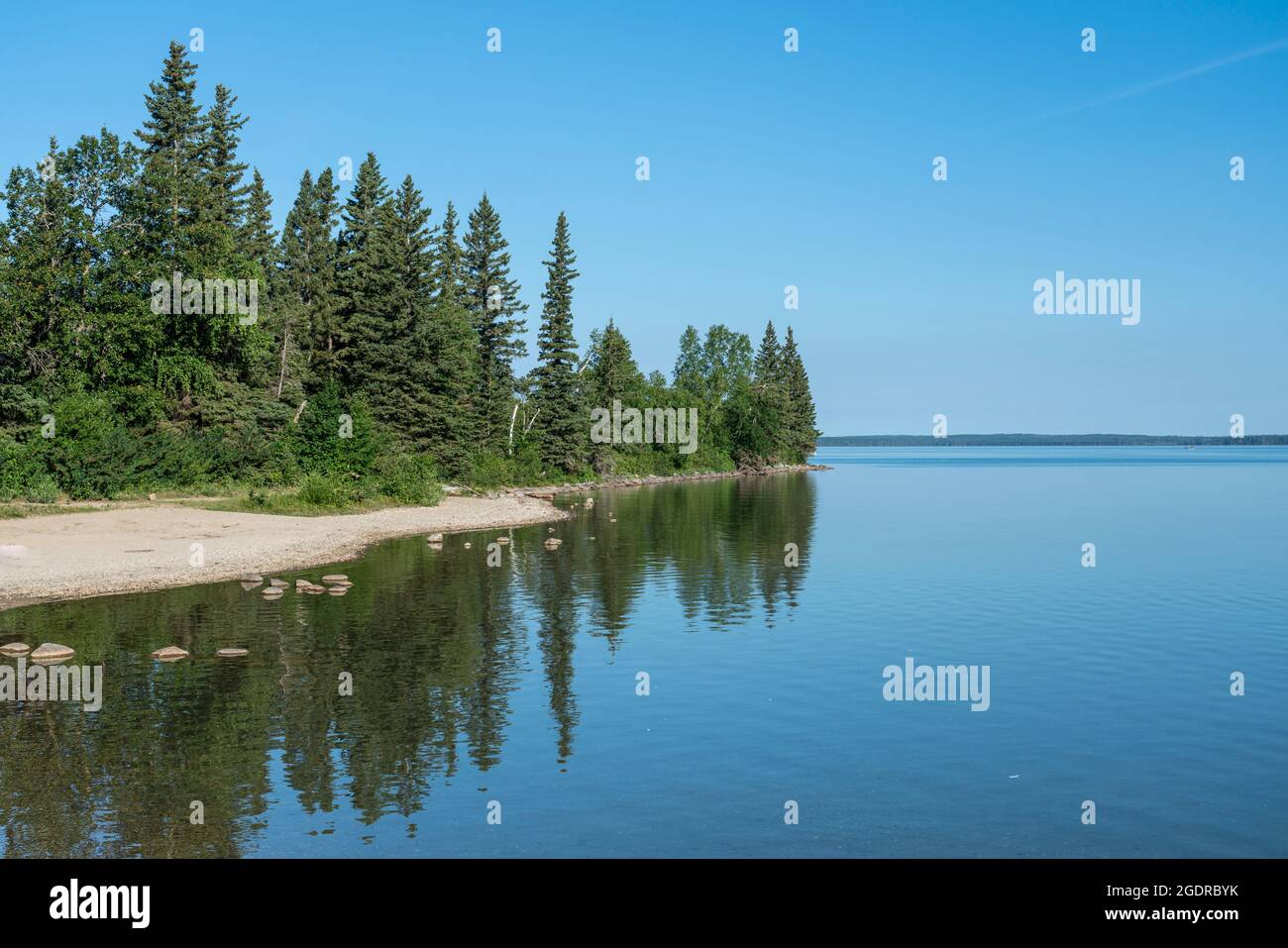 Le rivage du lac Clear avec des reflets dans le parc national du Mont-Riding, Manitoba, Canada. Banque D'Images