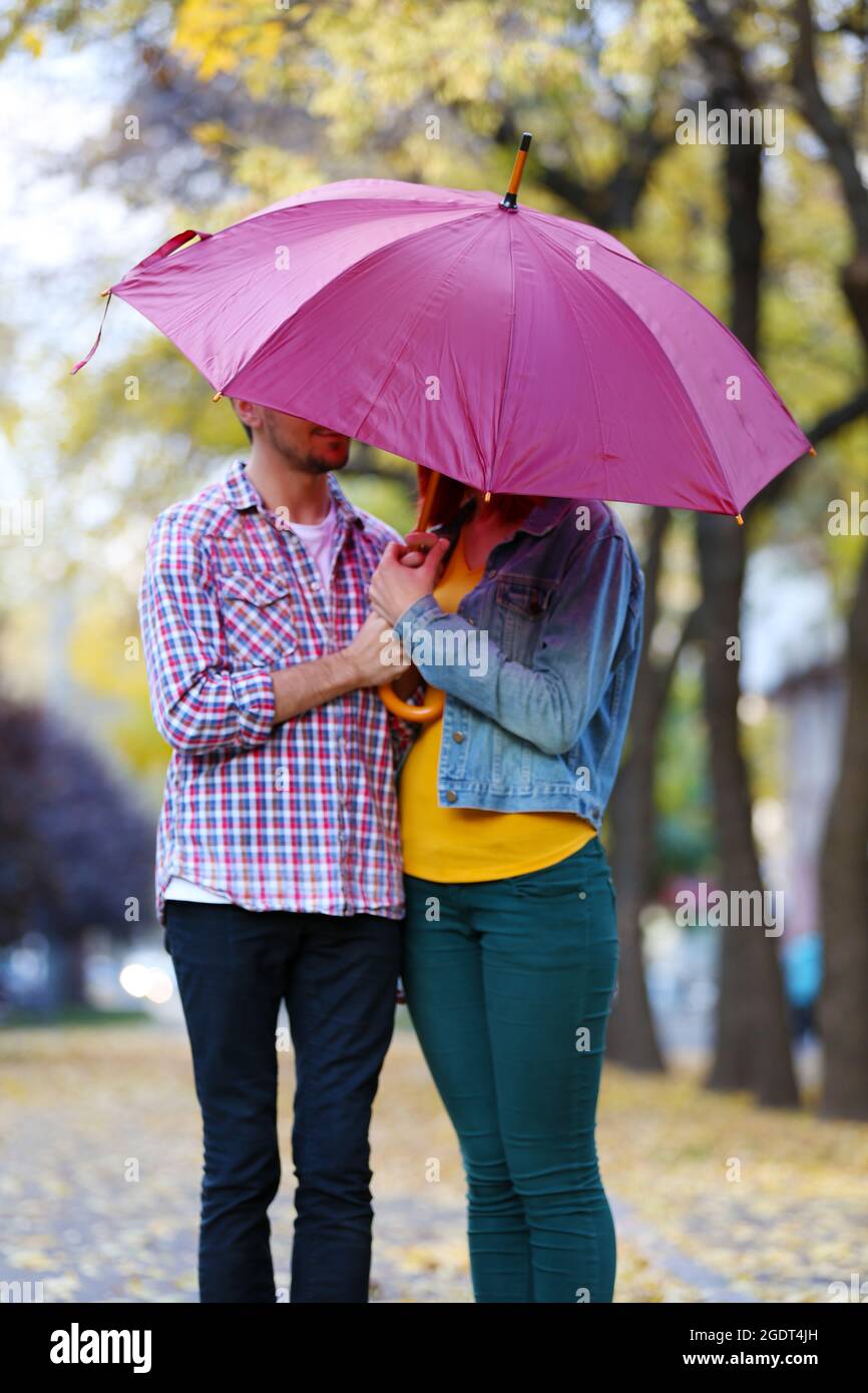 Couple amoureux sous un parapluie dans le parc d'automne Photo Stock - Alamy